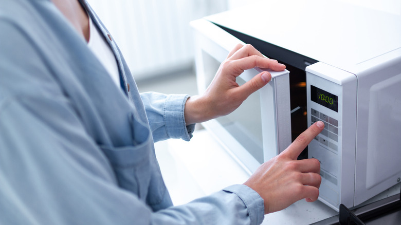 Woman operating microwave