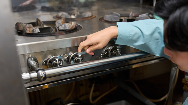 A man checking a gas stove