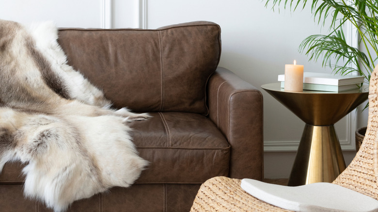 Fur rug draped over brown leather sofa