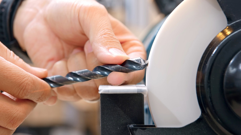 a person sharpening a drill bit