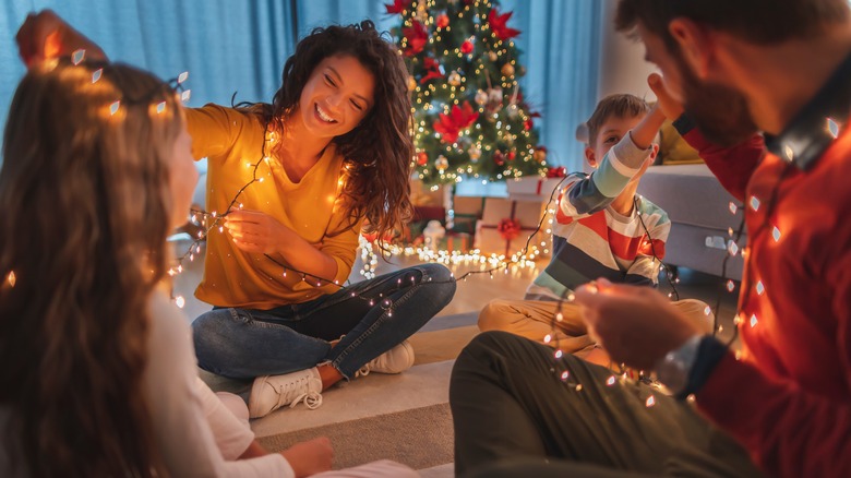 family playing with Christmas lights