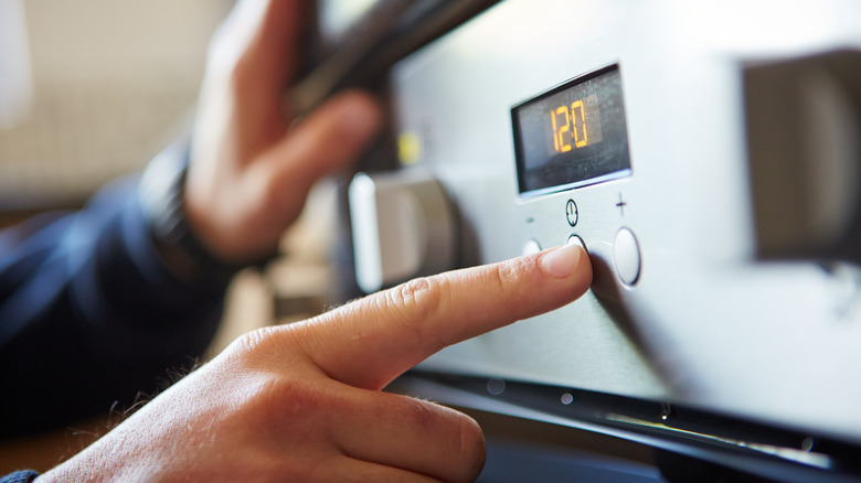 Hand pressing stove buttons