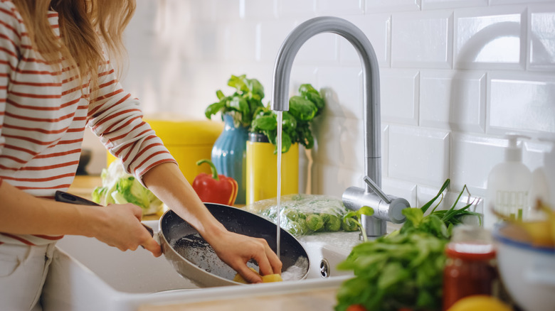 Woman washing frying pan 