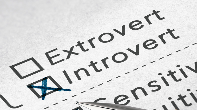 The words "extrovert" and "introvert" on a paper with a box checked next to introvert