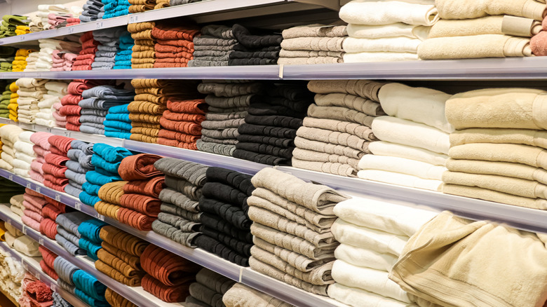 Neatly folded towels in a variety of colors on a store shelf