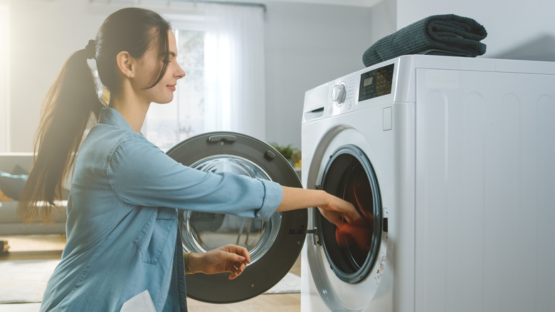 woman putting clothes in washer