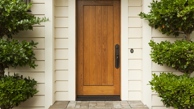 wooden front door and shrubs