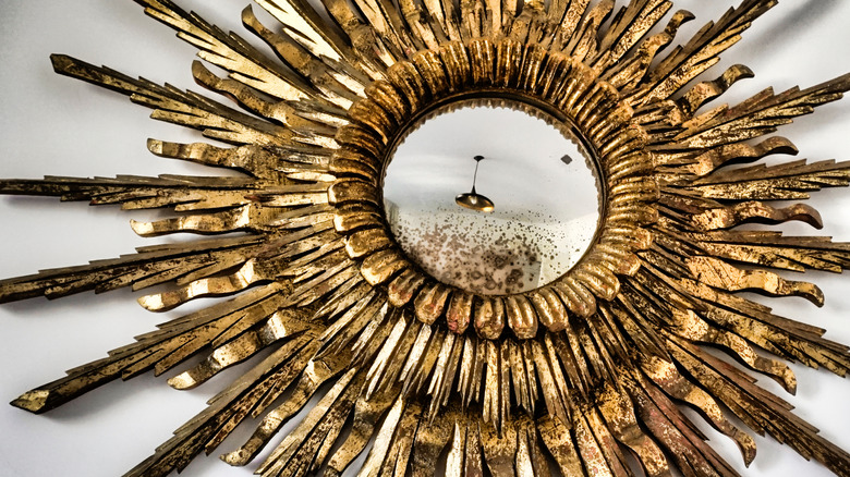 An antique gold starburst mirror