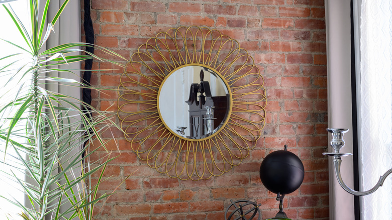 A sunburst mirror on brick wall