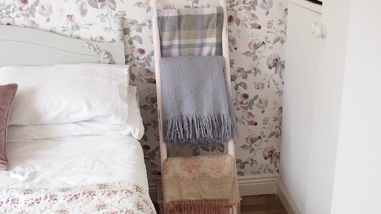 SATSUMAS Plant stand holding blankets in a bedroom