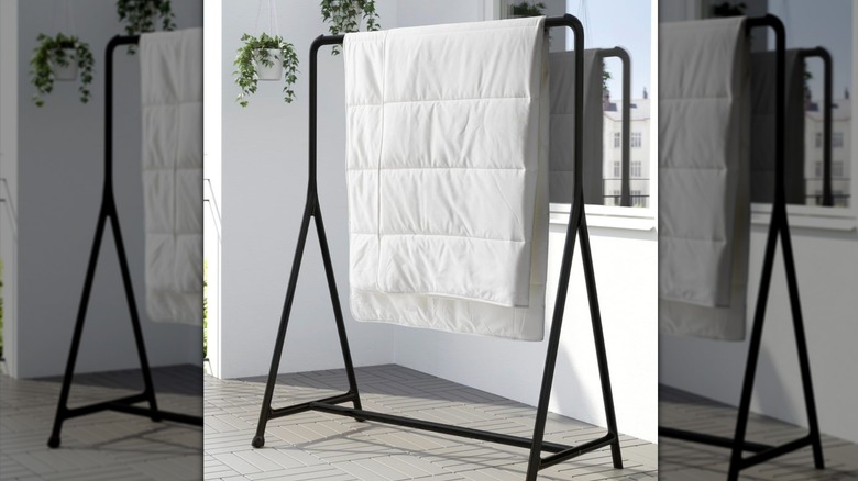 TURBO Clothes rack with a duvet blanket hung over it