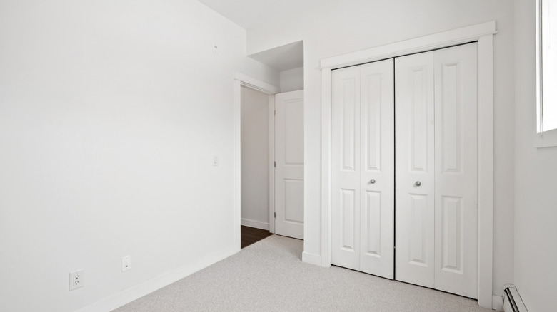 A white room with large white bifold closet doors