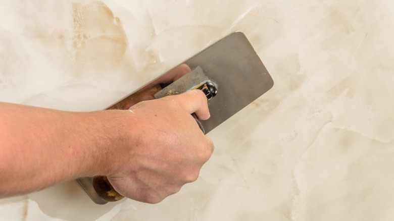 Adding a thin layer of drywall mud to wall for Venetian drywall