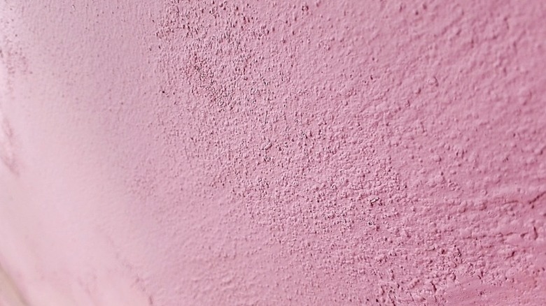 A closeup of a pink wall with orange peel texture