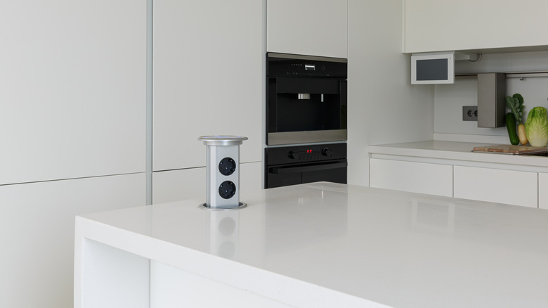 A pop-up power socket mounted in a modern kitchen counter