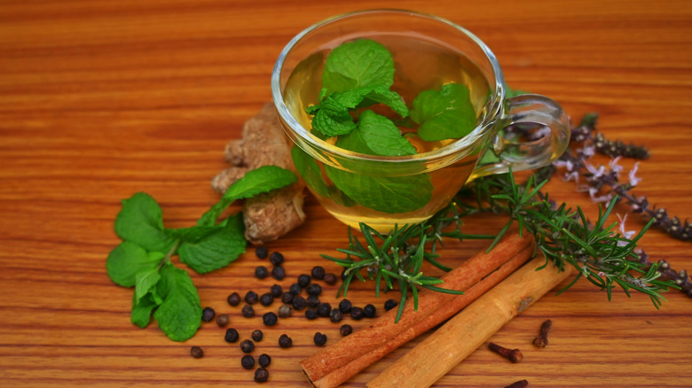 Peppermint and cinnamon sticks are among the herbs set out on a cutting board