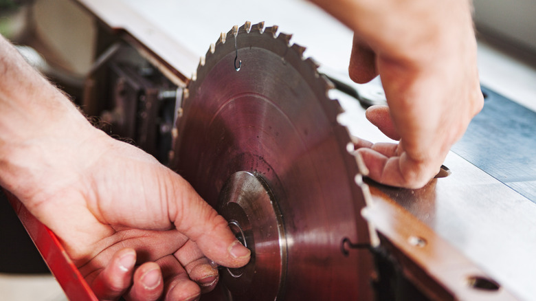 person changing a table saw blade