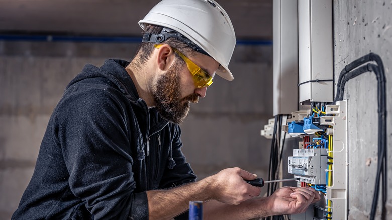 Electrician works on switchboard