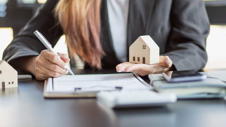 real estate agent holding a small home