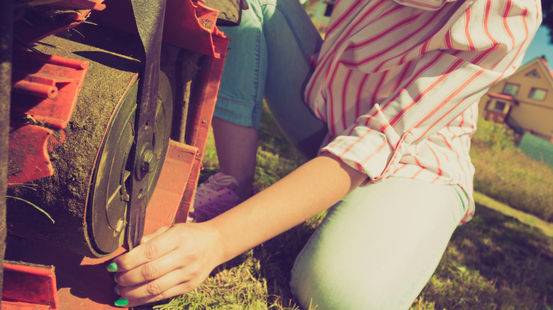 person checking lawnlower