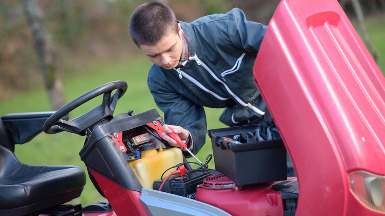 man checking lawnmower