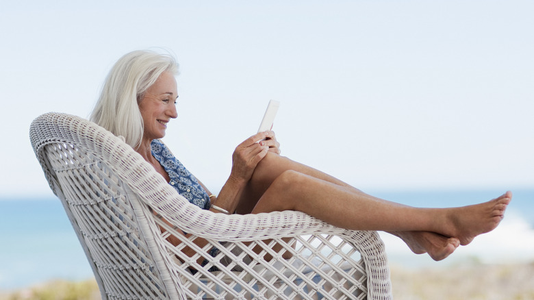 woman lounging in wicker chair