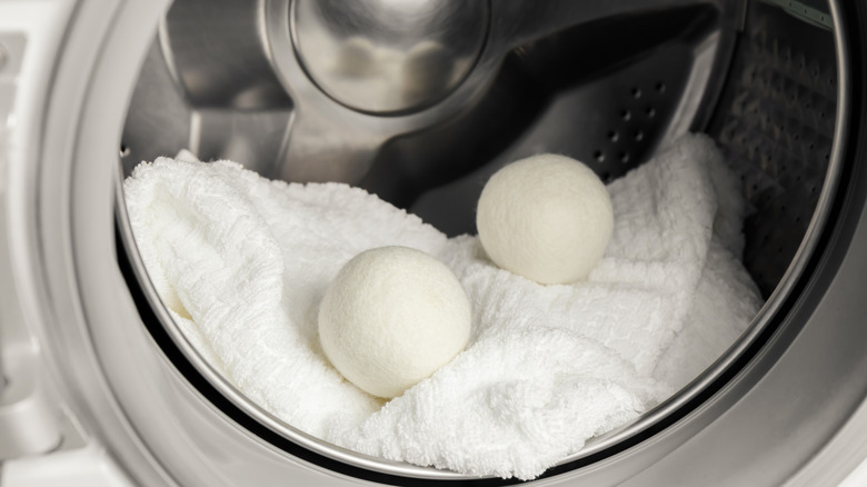 Wool dryer balls in open dryer on top of white towels