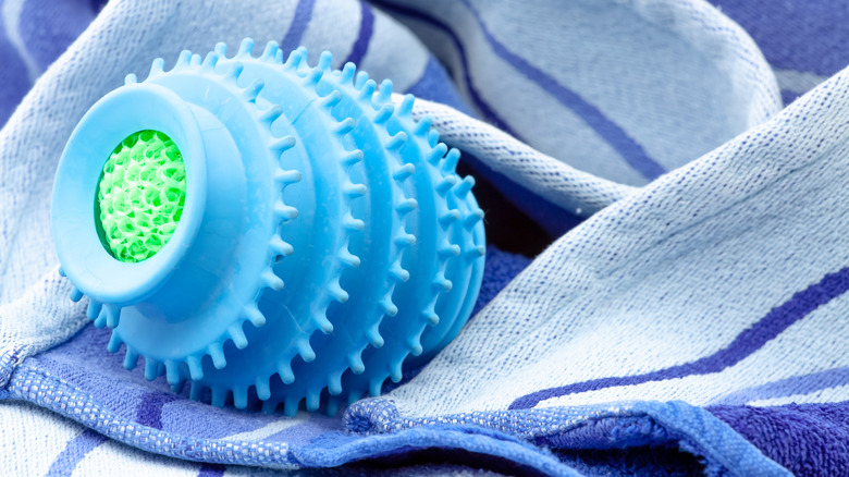 Close up of blue and green silicone dryer balls sitting on some towels