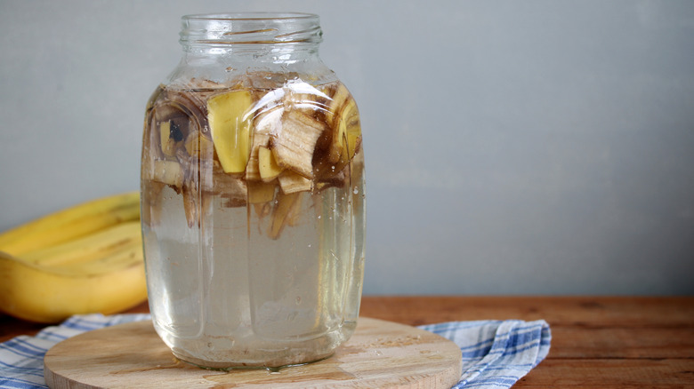 A glass bottle filled with banana peels and vinegar.