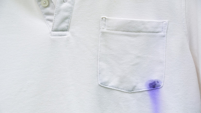 A white t-shirt with a blue ink stain on the chest pocket