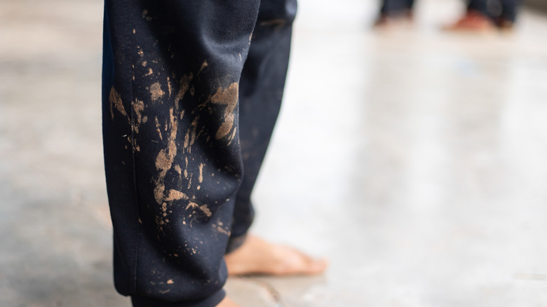 Mud stains on the ends of black pants