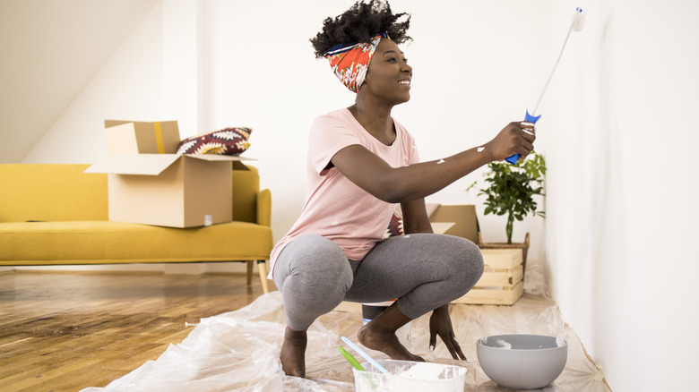 Smiling woman painting a wall
