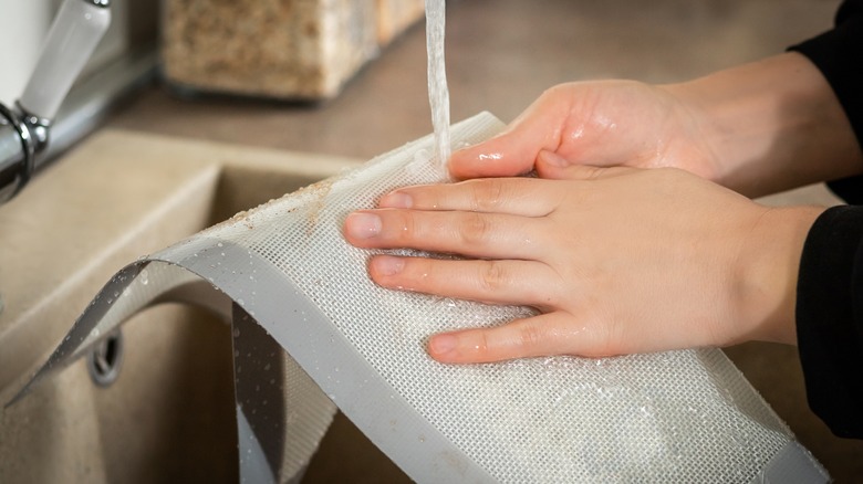 Person washing silicone baking mats