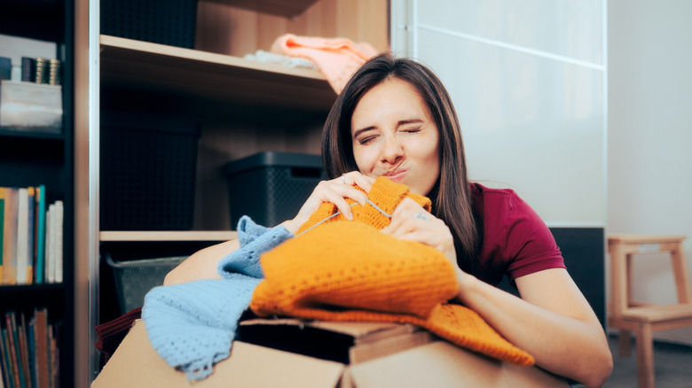 Woman smelling clothes in a box