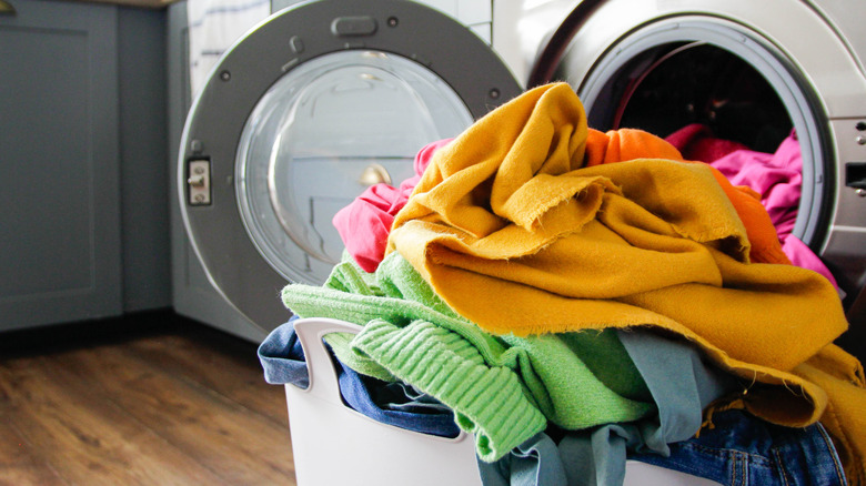 Basket of clean laundry by washing machine and dryer