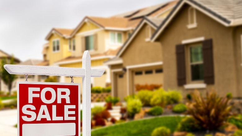 House with red for sale sign 