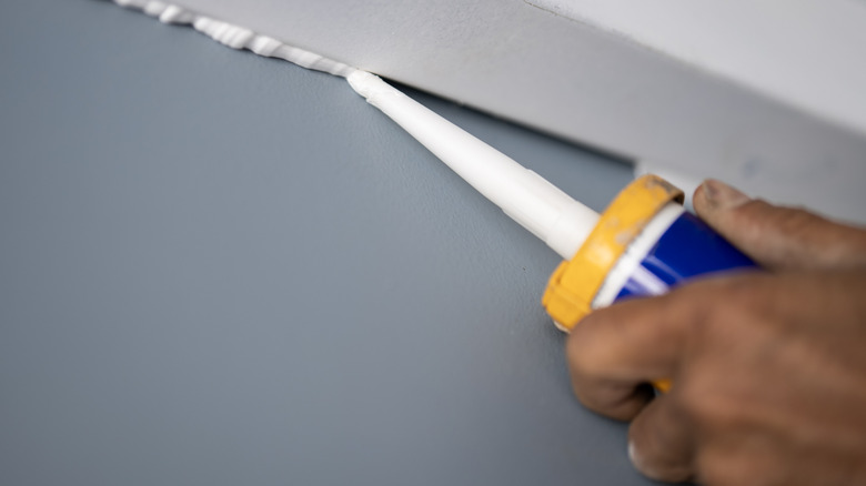 Man using caulk for house project