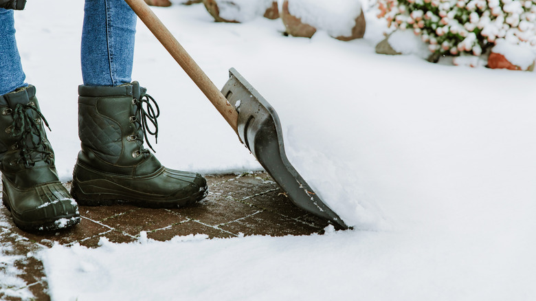 Person's boots and snow shovel