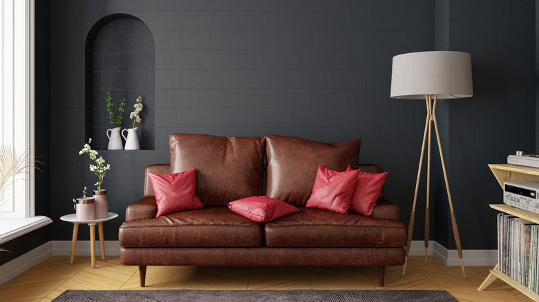 Dark leather couch against charcoal-colored brick wall