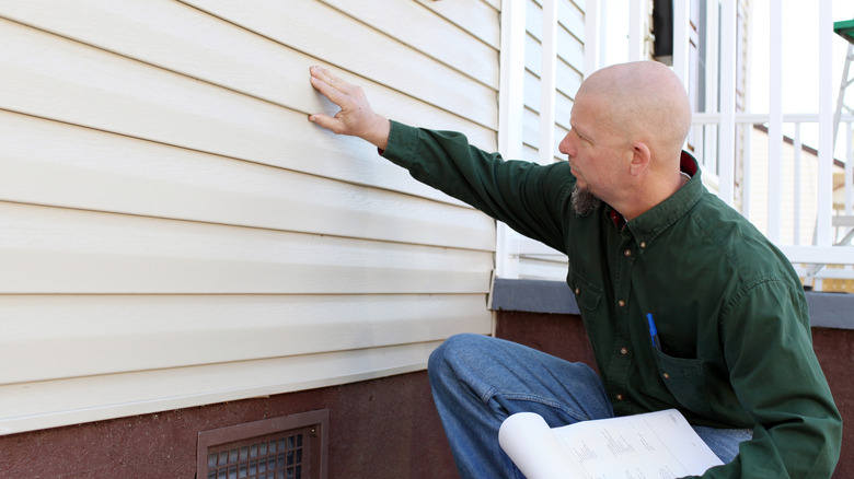 Inspector looking at aluminum siding
