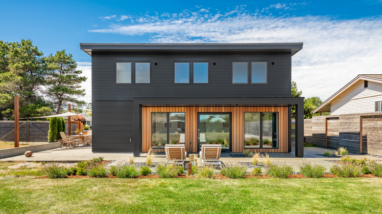 Modern home with black steel siding and wooden accents
