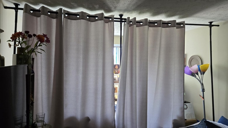 gray curtain room divider hung on tension poles