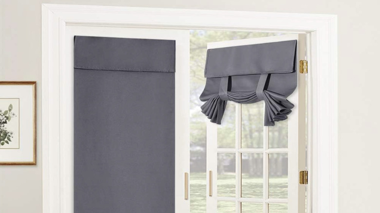 Two gray curtains on French doors with one folded up