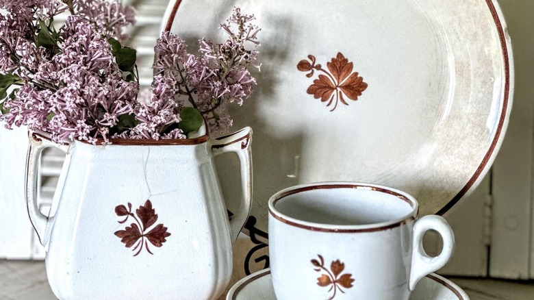 tea leaf ironstone dishware set with plate, mug, and vase holding dried flowers