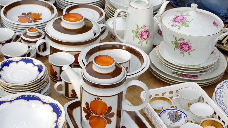 Vintage dishware in an array of colors stacked on top of a table