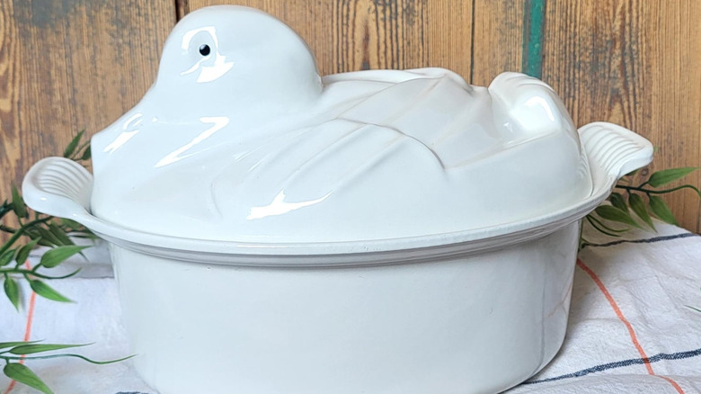 A white, duck-shaped Le Creuset dutch oven.