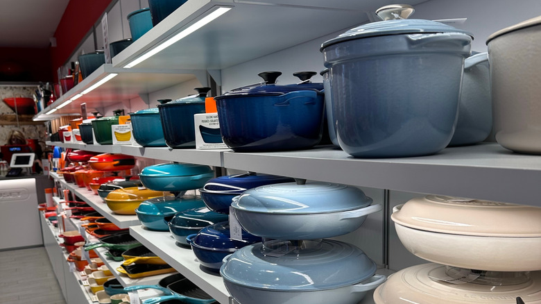 Display shelves with Le Creuset cookware arranged by color.