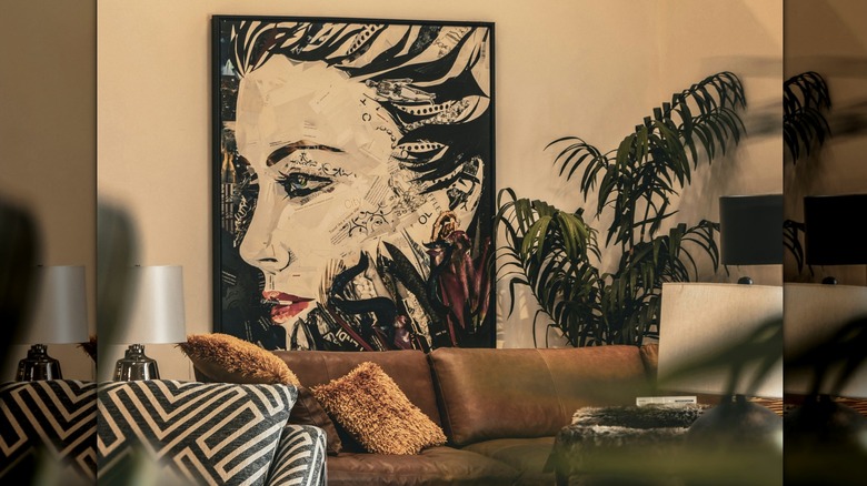 A bohemian living room with a large-scale artwork hung over the sofa