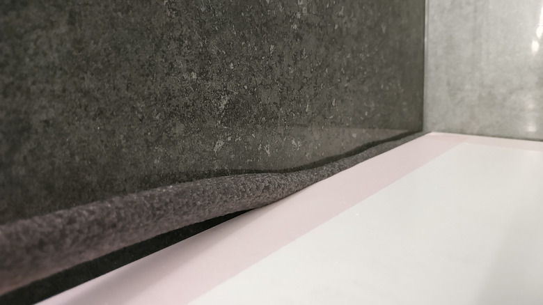 backer rod being inserted between tiles