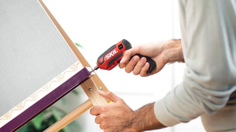 A person using the SKIL Rechargeable 4V Cordless Screwdriver on an easel.